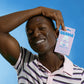 Person holding a BEAME UV SPF sticker pack against a blue background.